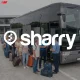 Sharry на фоні черги людей, які стоять біля автобусу